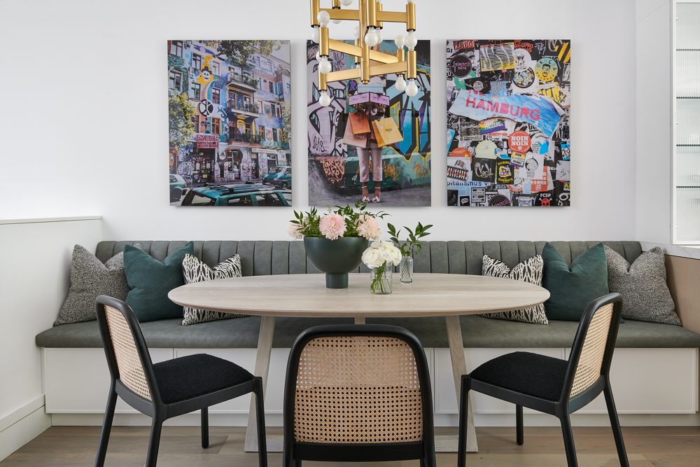 A breakfast nook with a banquette, cane chairs and a brass pendant