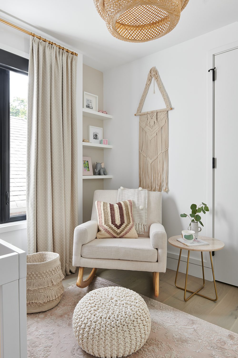 A nursery corner with a cream armchair and a rattan pendant
